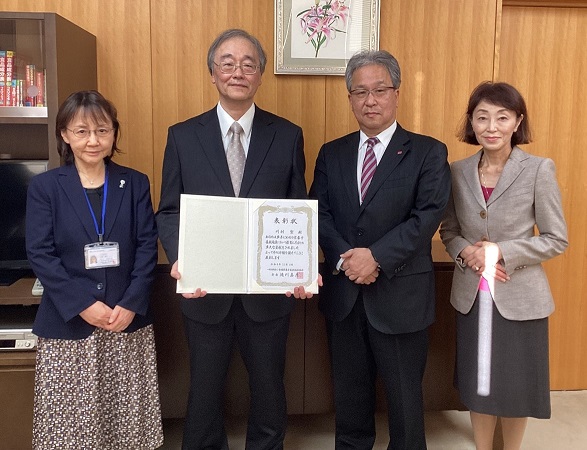 写真左より川端副学長、川村教授、香川学長、武見副学長