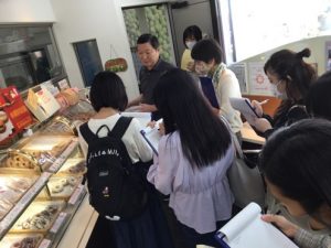 学生が㈱三代目清水屋を訪問し、会社や販売している商品の種類、特徴について説明を受けている様子
