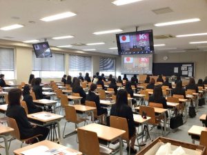 ▲教壇に花が飾られた各教室では密にならないよう配慮し、モニターを通して式典に参加。